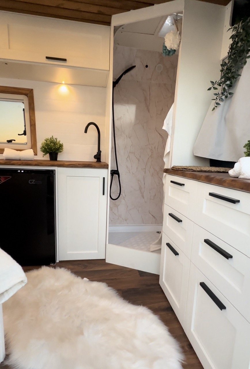 Cocina de la camper con fregadero, grifo y estanterías